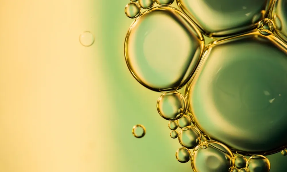 Carboroil_Biodiesel: composição e impacto da mistura no combustível Bolhas de óleo em fundo líquido esverdeado, representando a composição e mistura do biodiesel.