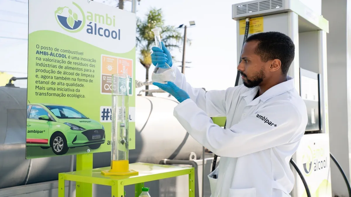 Carboroil_Ambipar Etanol resíduos Cientista da Ambipar analisa amostra de etanol reciclado em posto sustentável, destacando inovação na transformação de resíduos alimentares em combustível renovável.